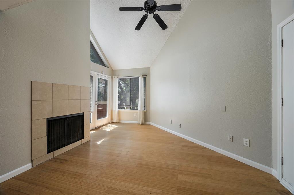 a view of empty room with wooden floor and fireplace