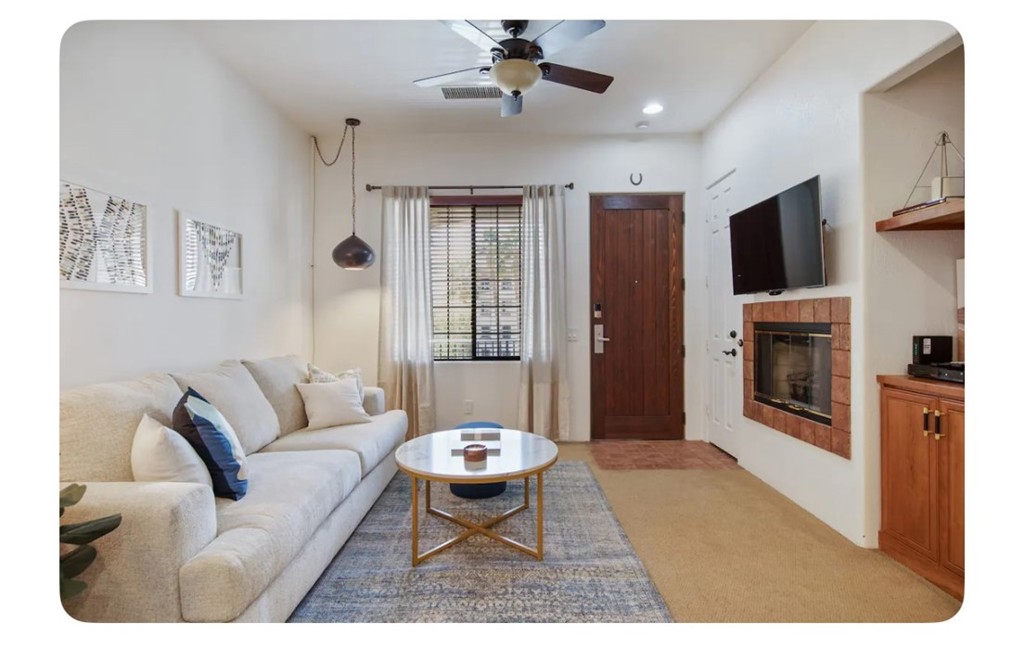 a living room with furniture a fireplace and a flat screen tv