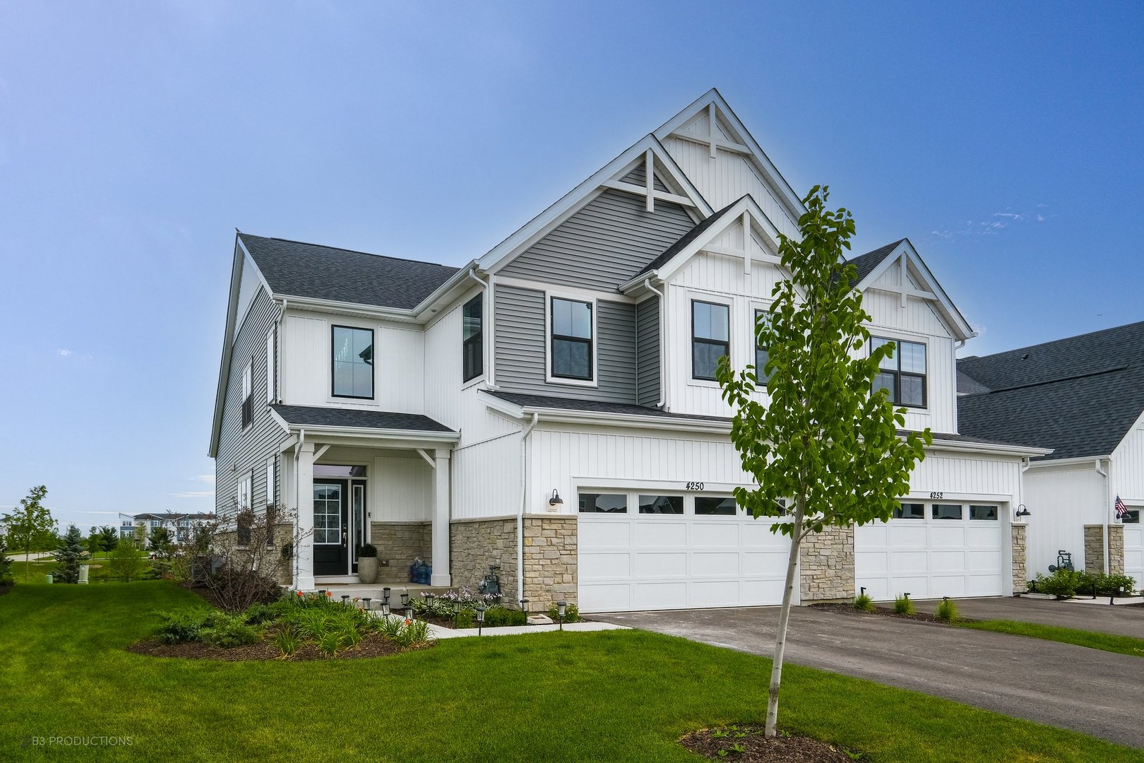 a front view of a house with a yard and trees