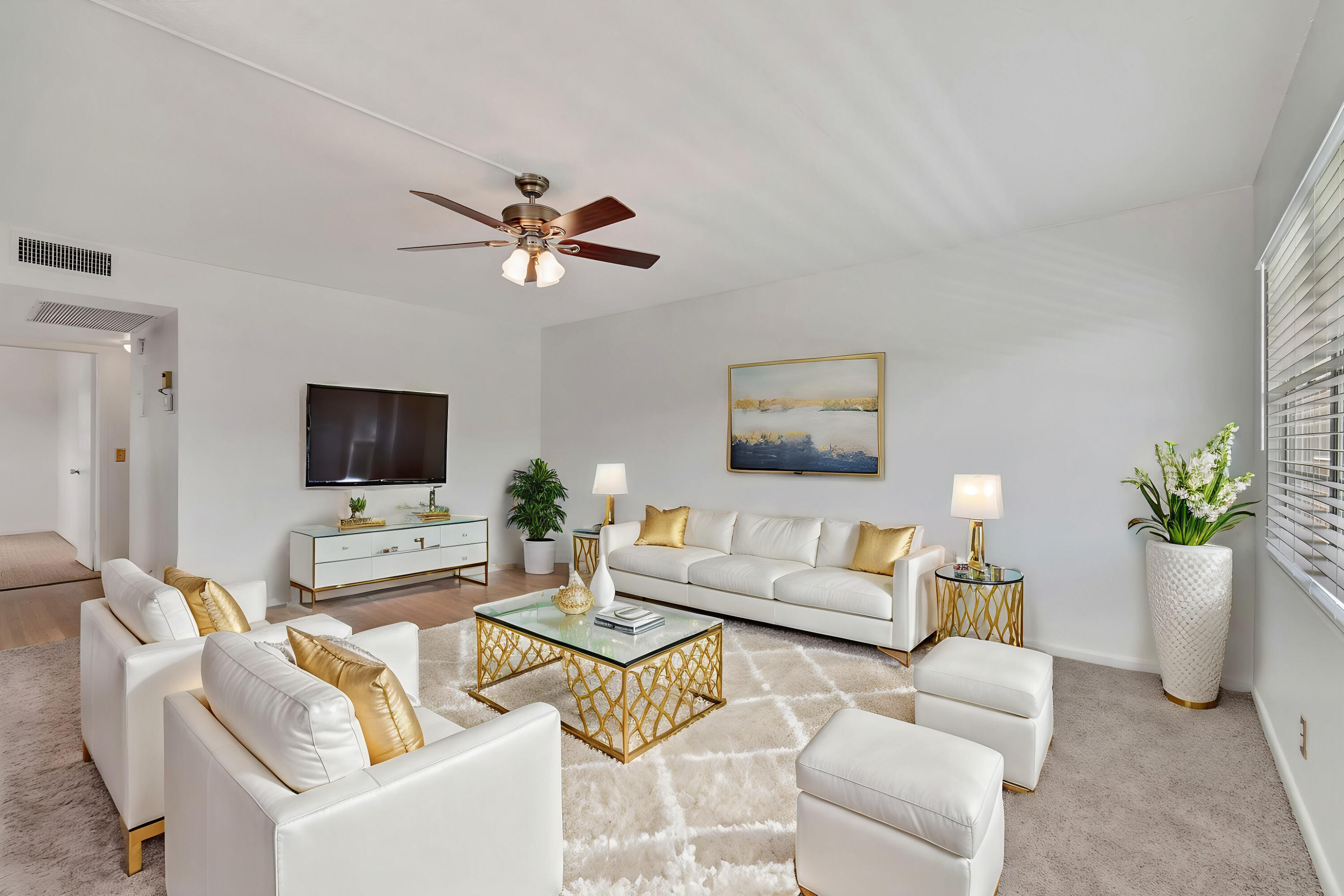 a living room with furniture a flat screen tv and a potted plant