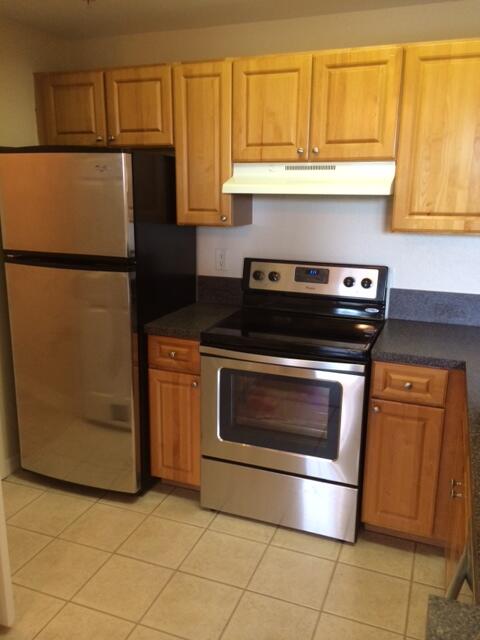 a kitchen with granite countertop cabinets and steel stainless steel appliances