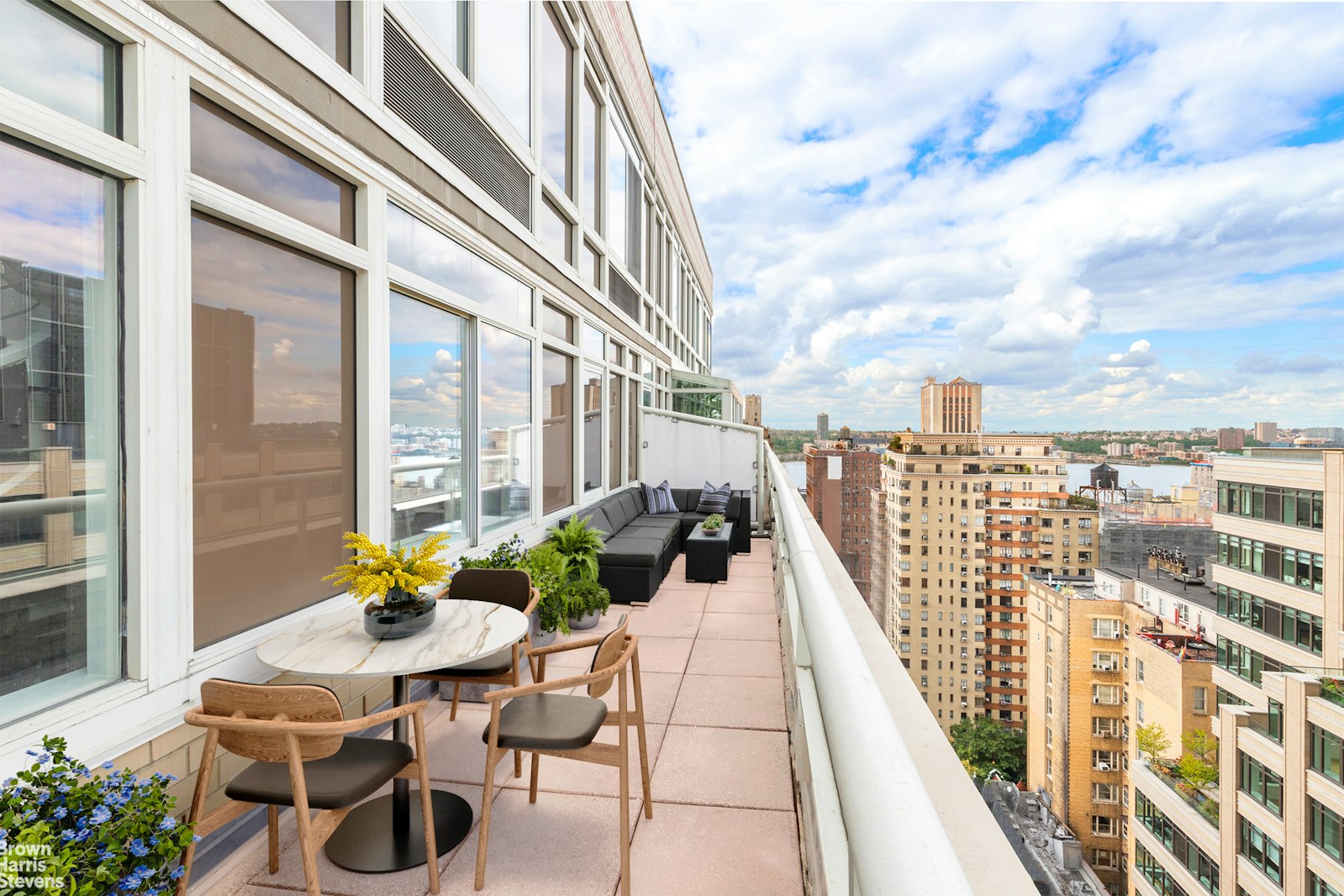 a view of a balcony with chairs and a potted plant