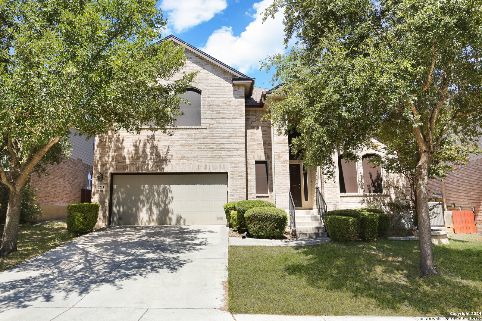 a view of a house with a yard and tree s