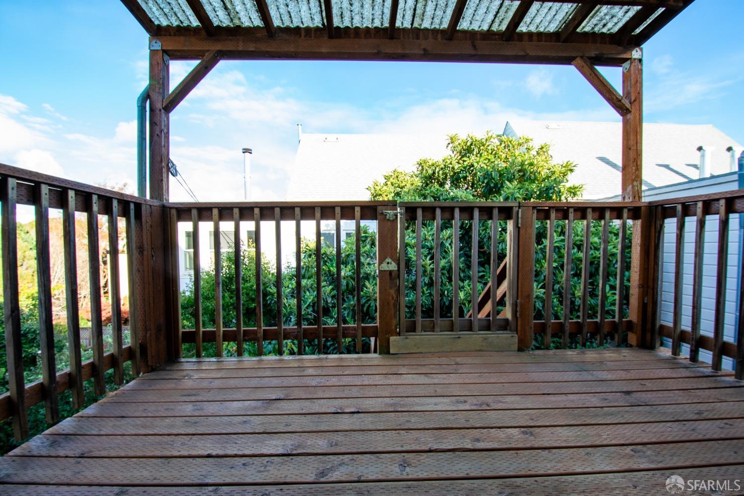 a view of backyard with a deck and wooden floor