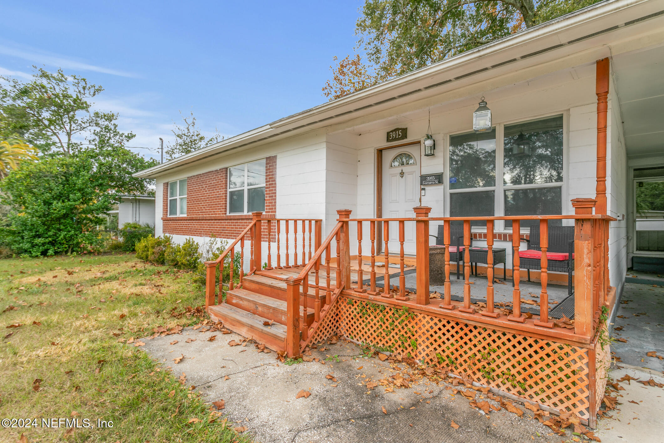 a view of a house with a small yard and wooden fence