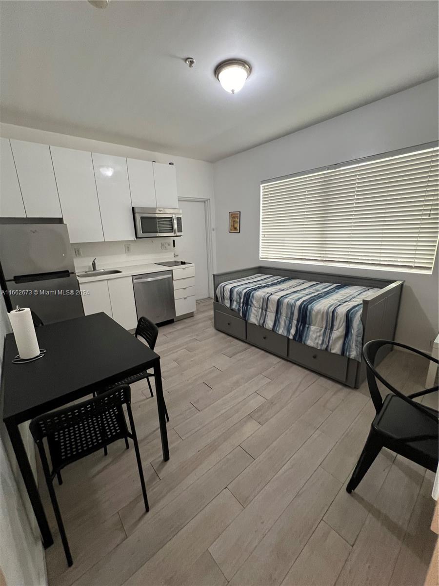 a kitchen with a table chairs microwave and cabinets