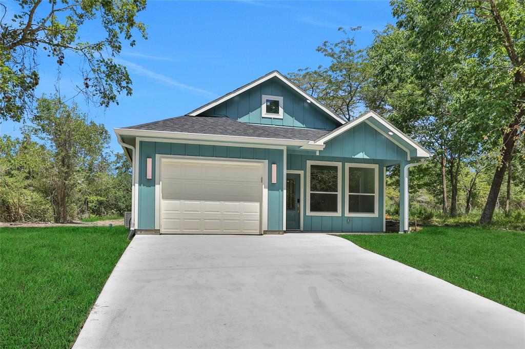 a front view of a house with yard and tree