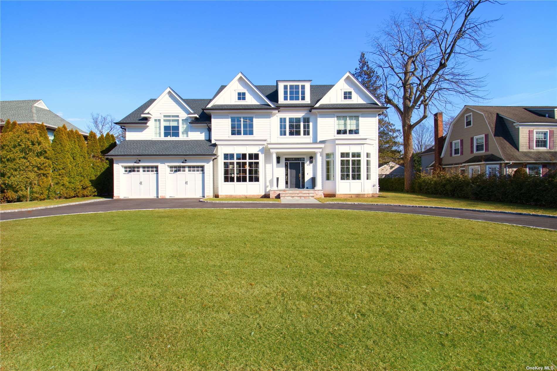 a front view of a house with a garden and lake view