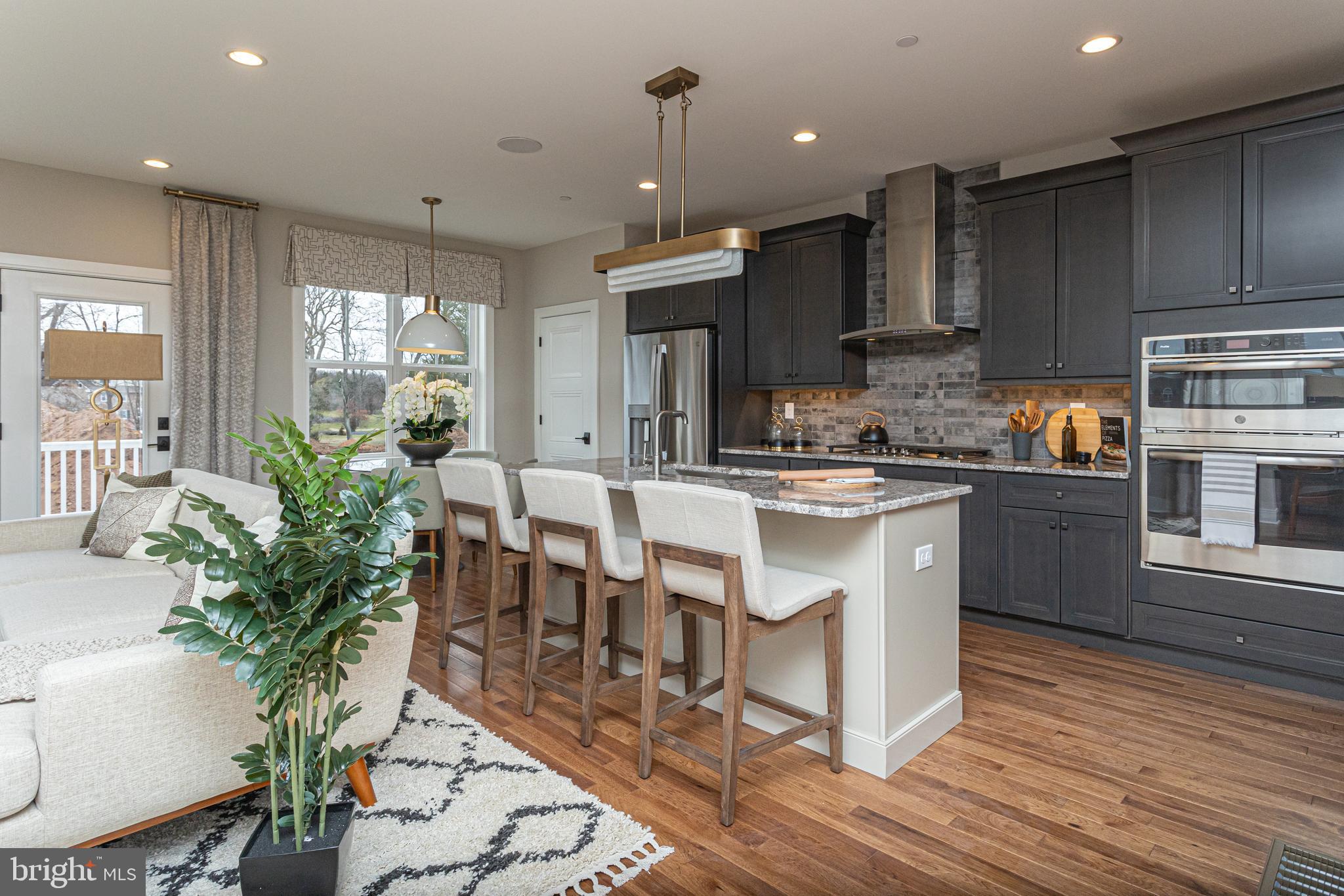 a kitchen with granite countertop a table chairs stove a sink and dishwasher