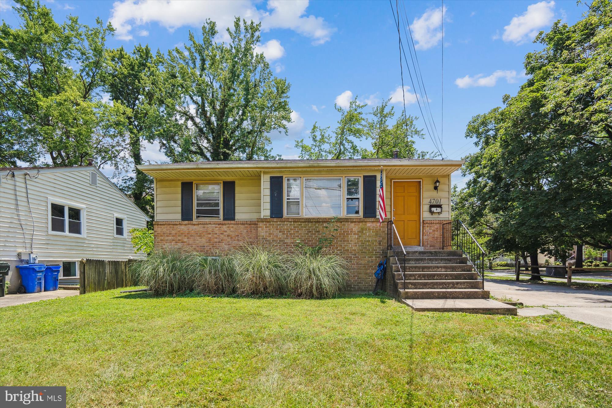 a front view of a house with a yard and trees