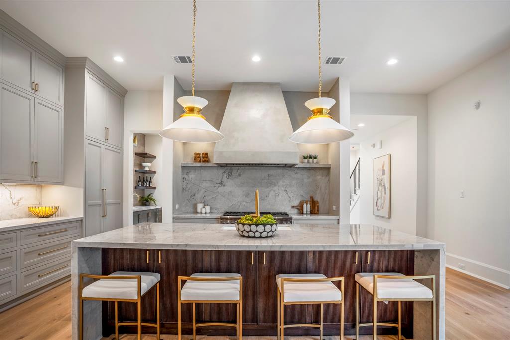 a kitchen with stainless steel appliances granite countertop a table chairs and a refrigerator