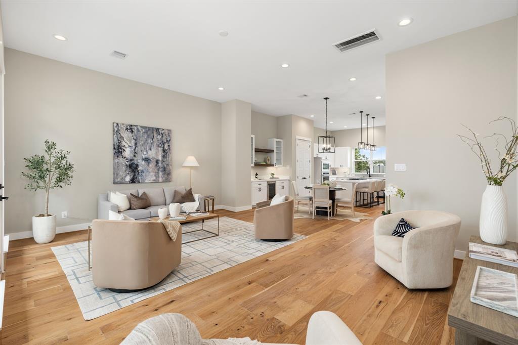 a living room with furniture and a dining table with wooden floor