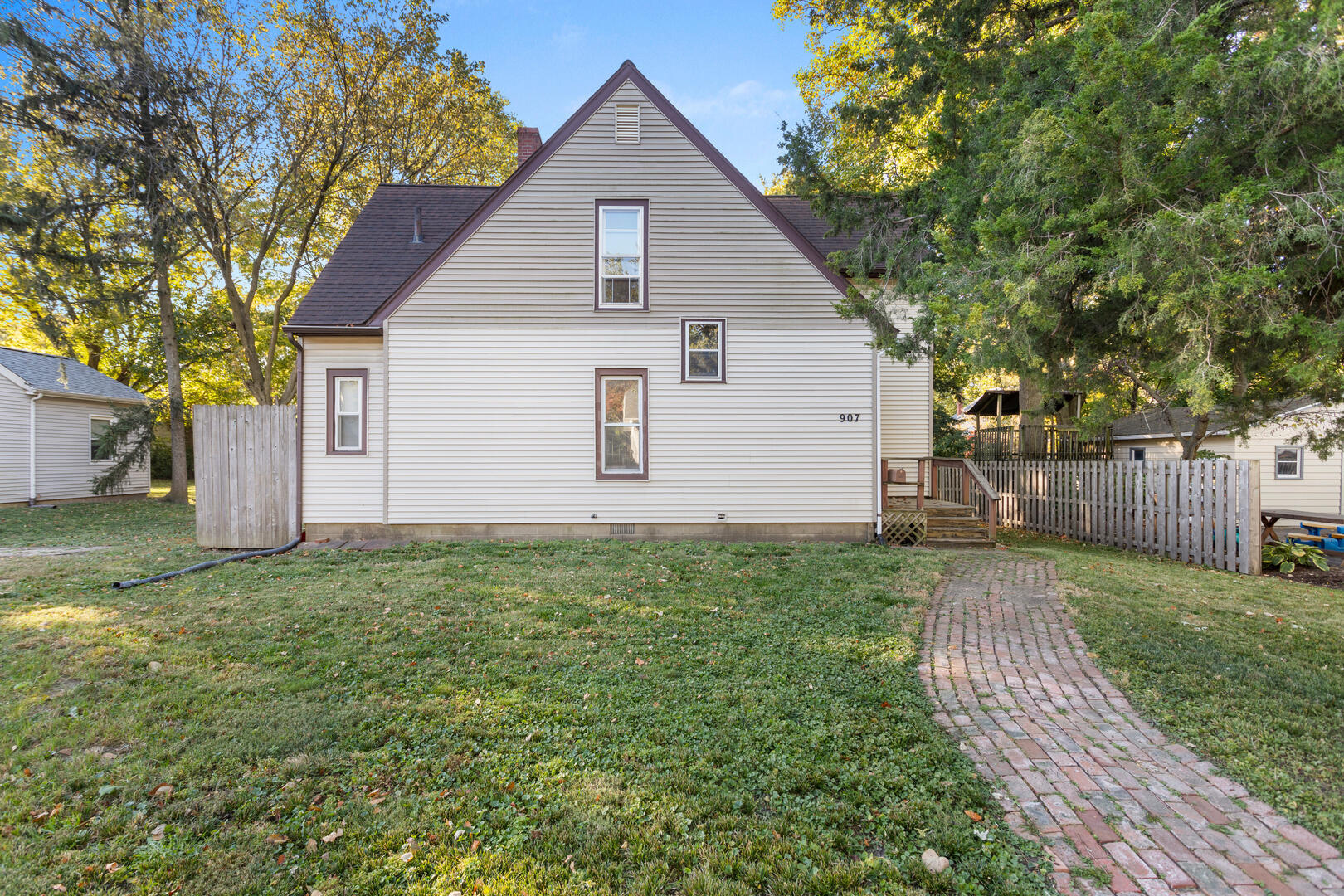 a view of backyard of house with wooden fence