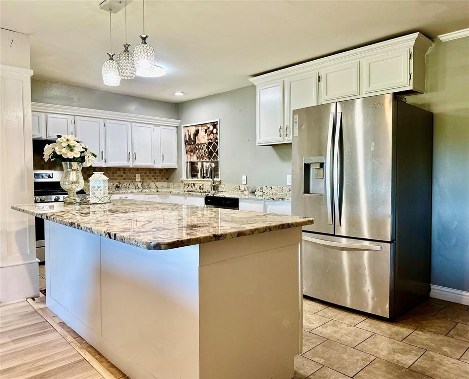 a kitchen with stainless steel appliances granite countertop a refrigerator a sink and a stove