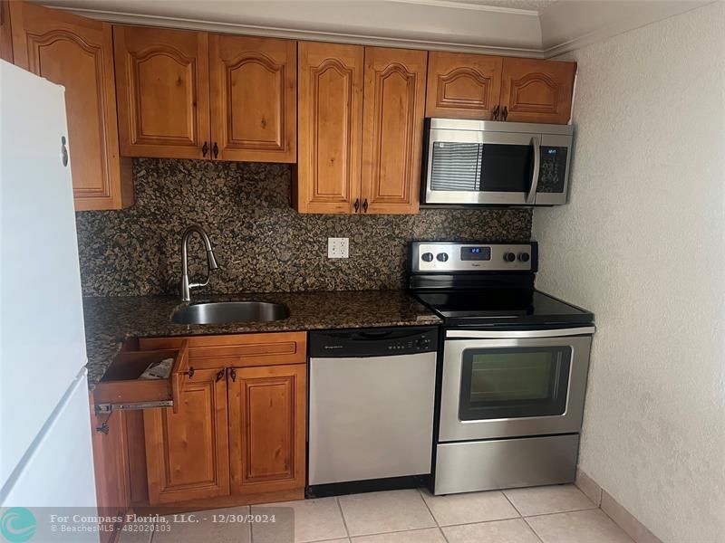 a kitchen with stainless steel appliances granite countertop a stove microwave and oven