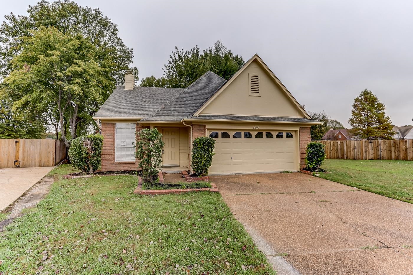 Single story home with a garage and a front lawn