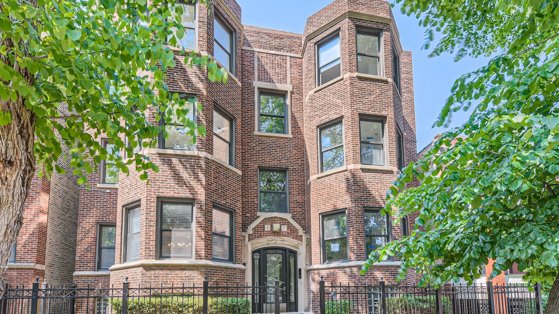 a front view of a multi story building with a yard