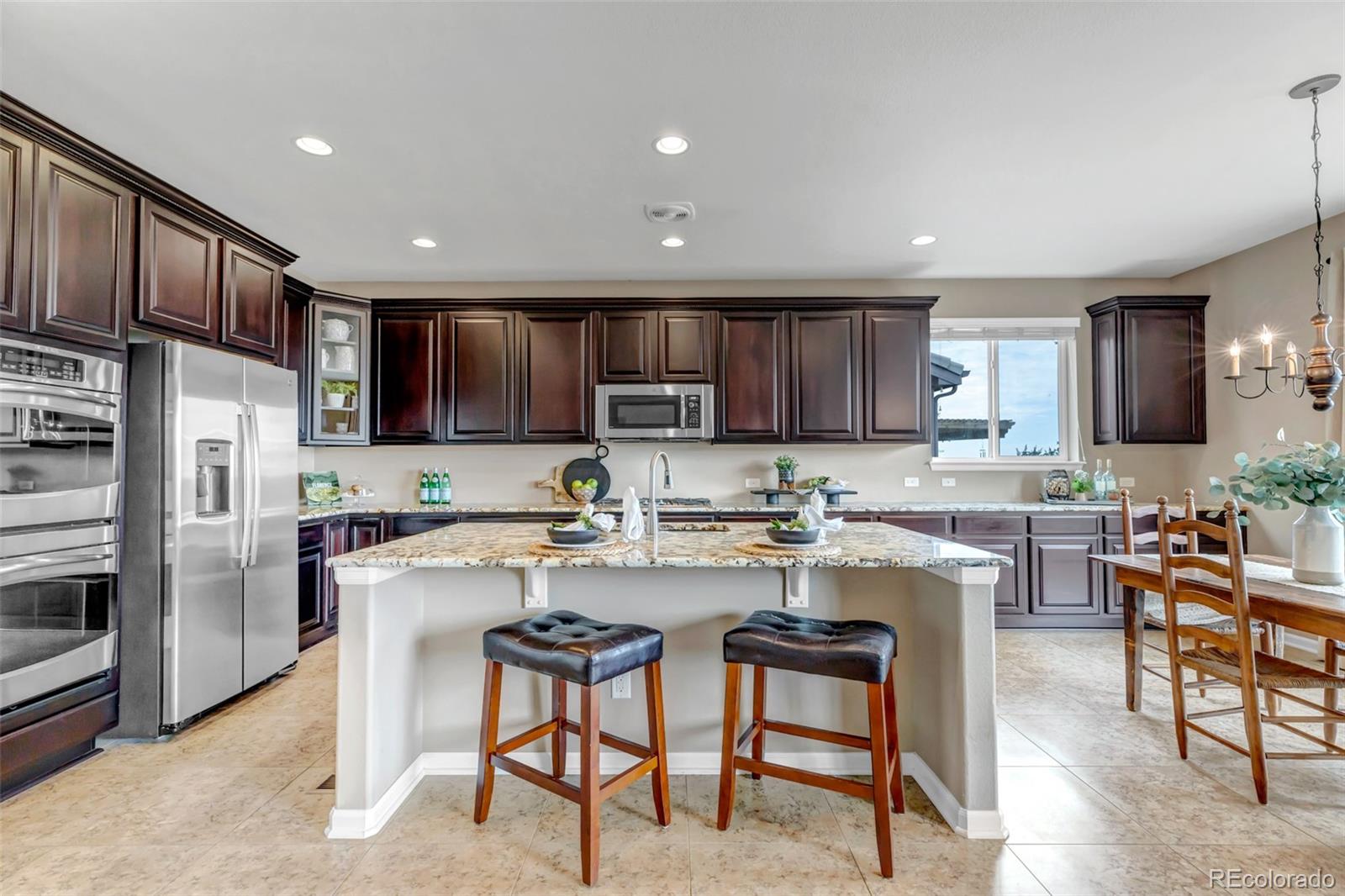 a kitchen with refrigerator and chairs