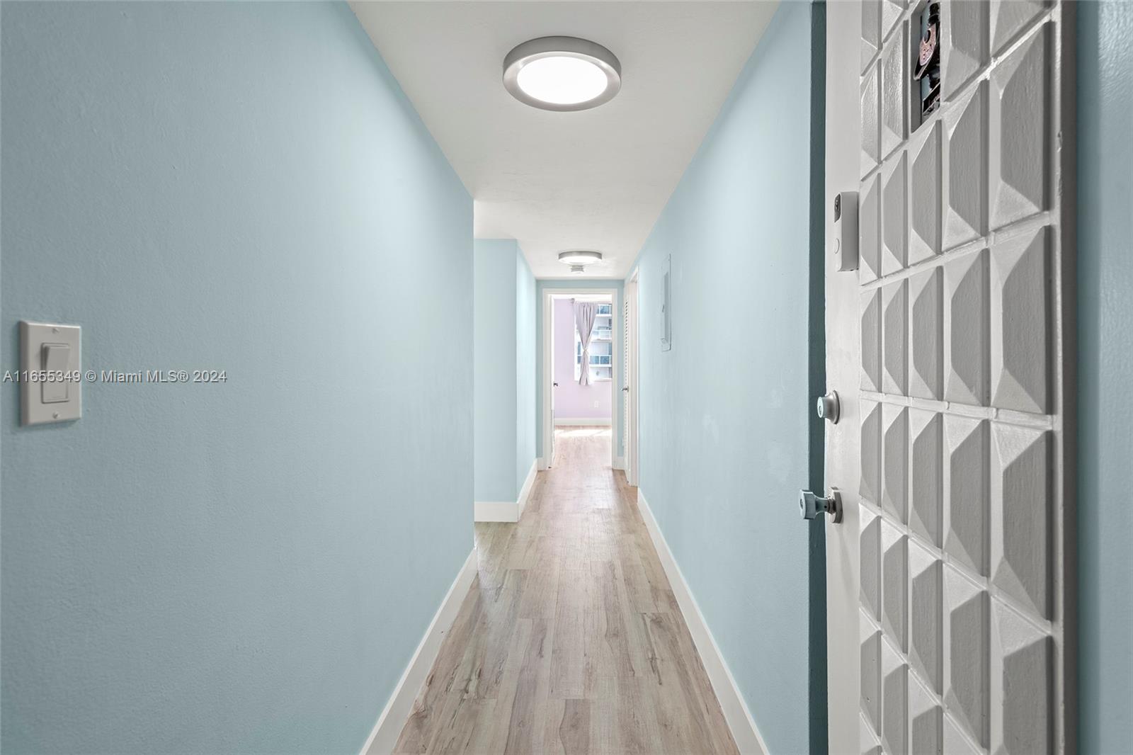 a view of a hallway with wooden floor and staircase