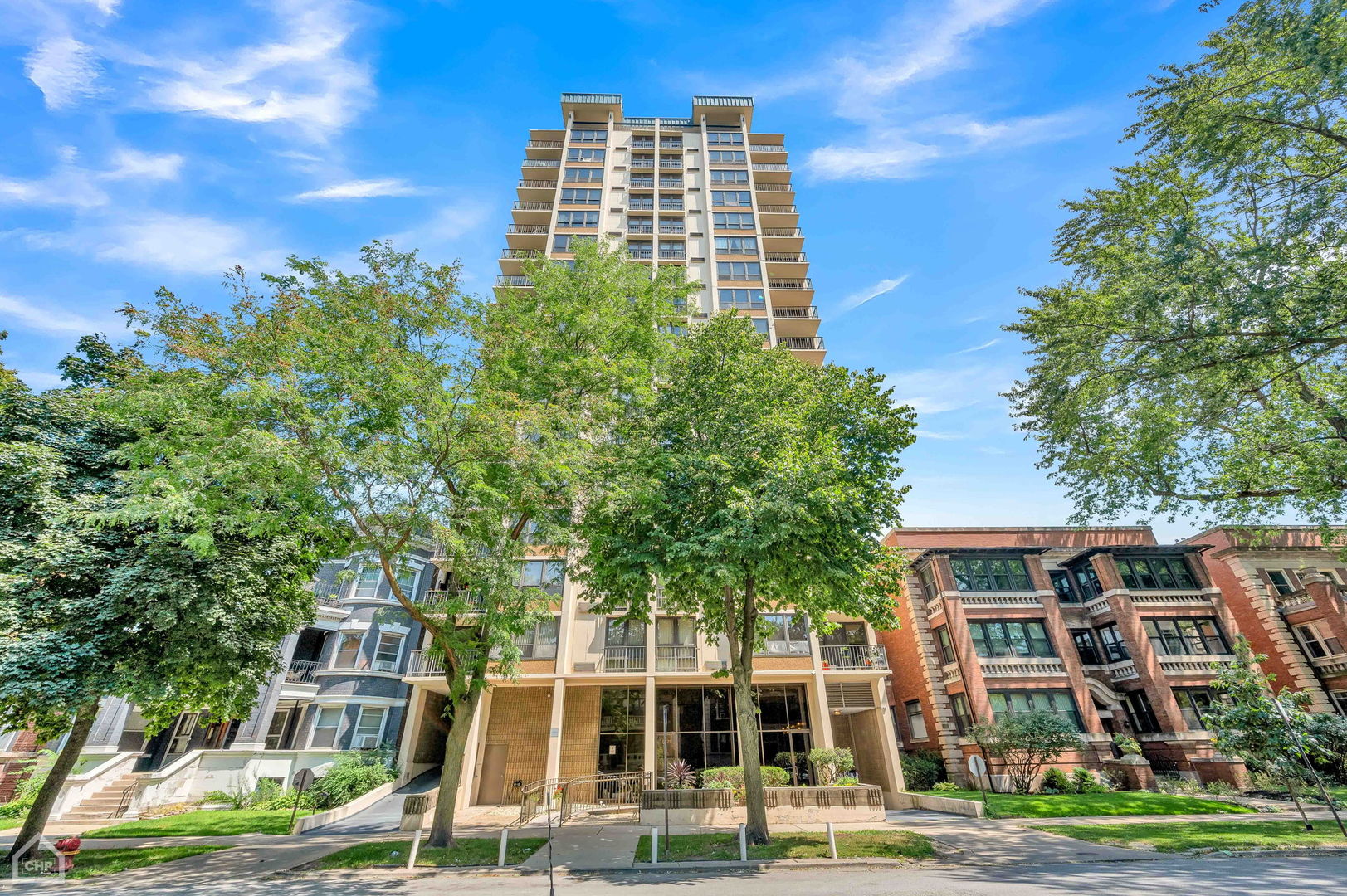 a front view of a multi story building with yard