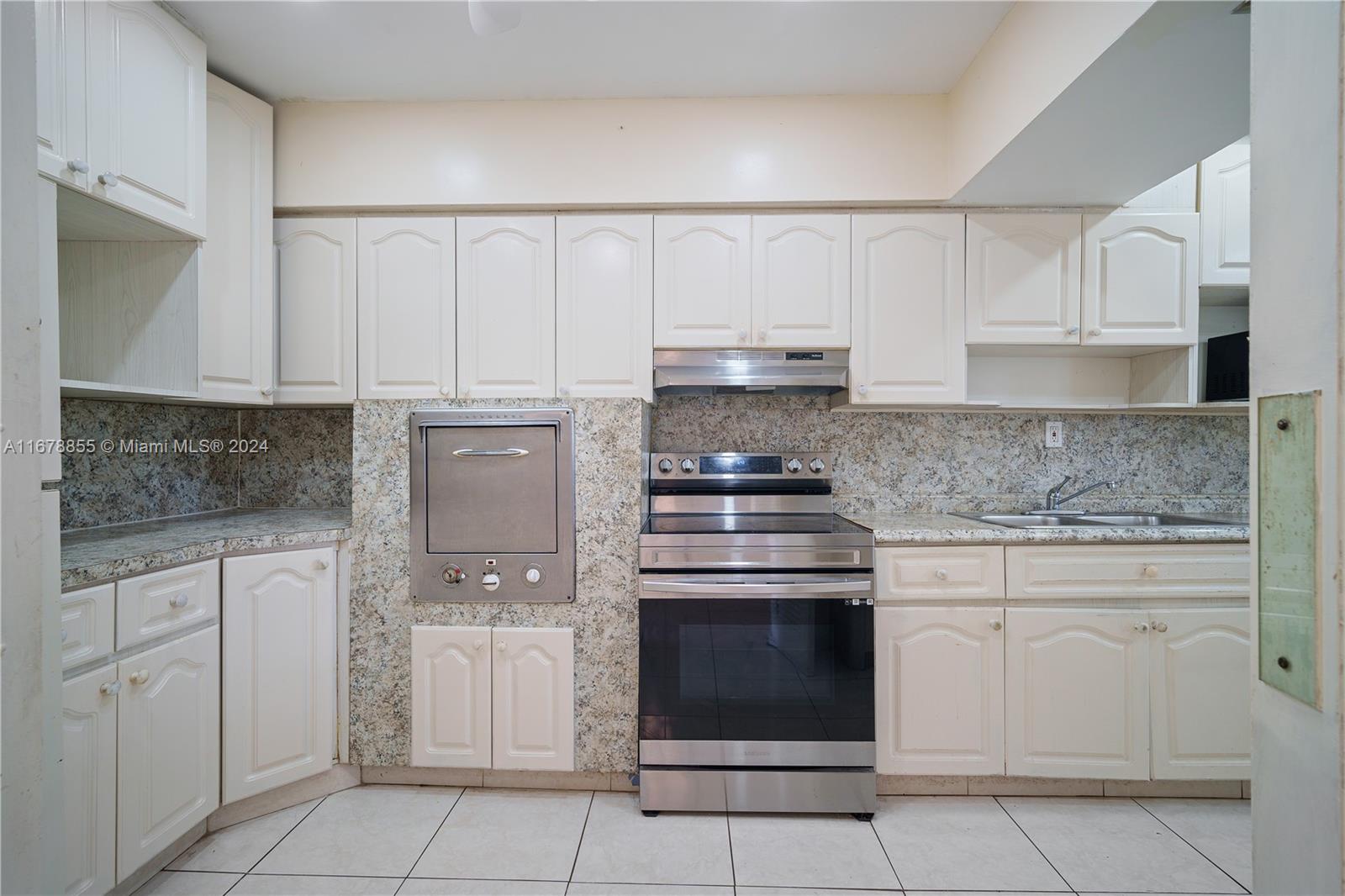 a kitchen with white cabinets and white appliances