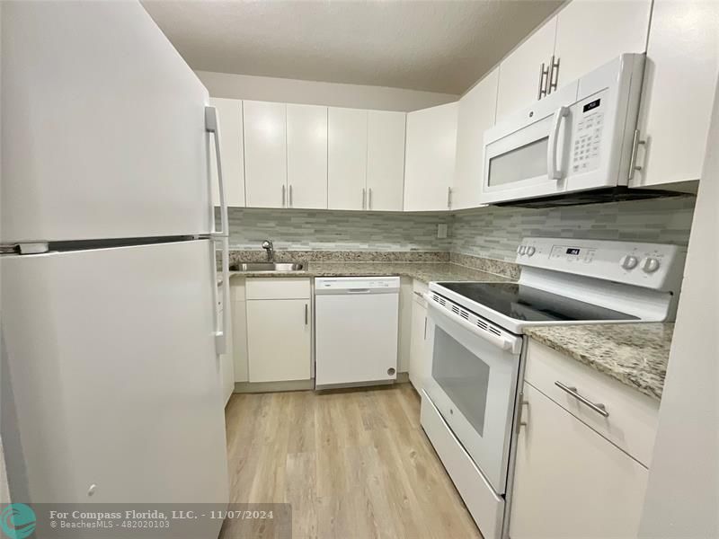 a kitchen with a sink cabinets and stainless steel appliances