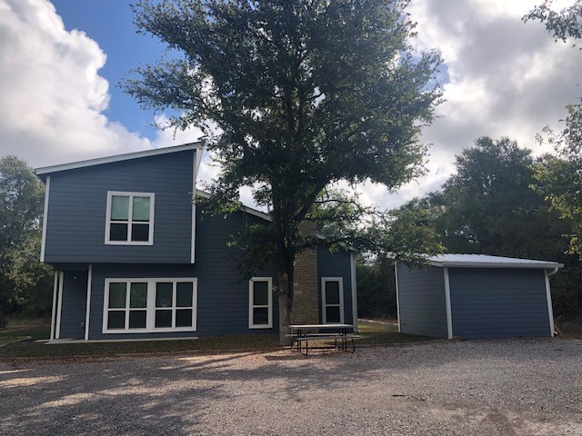 a front view of a house with a tree