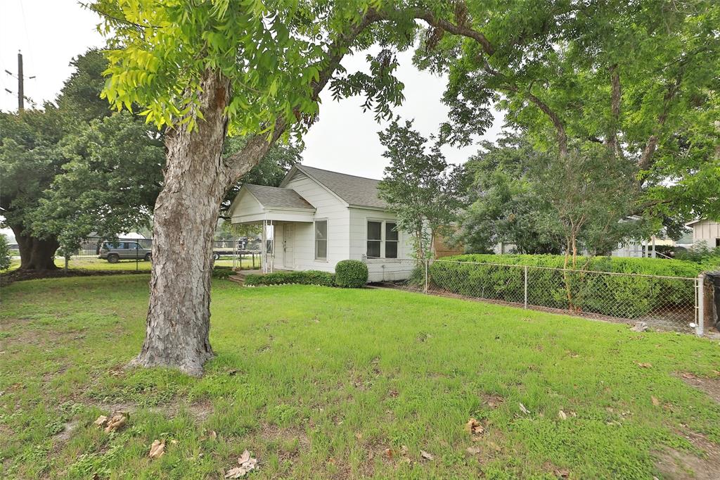 a view of a house with backyard and trees