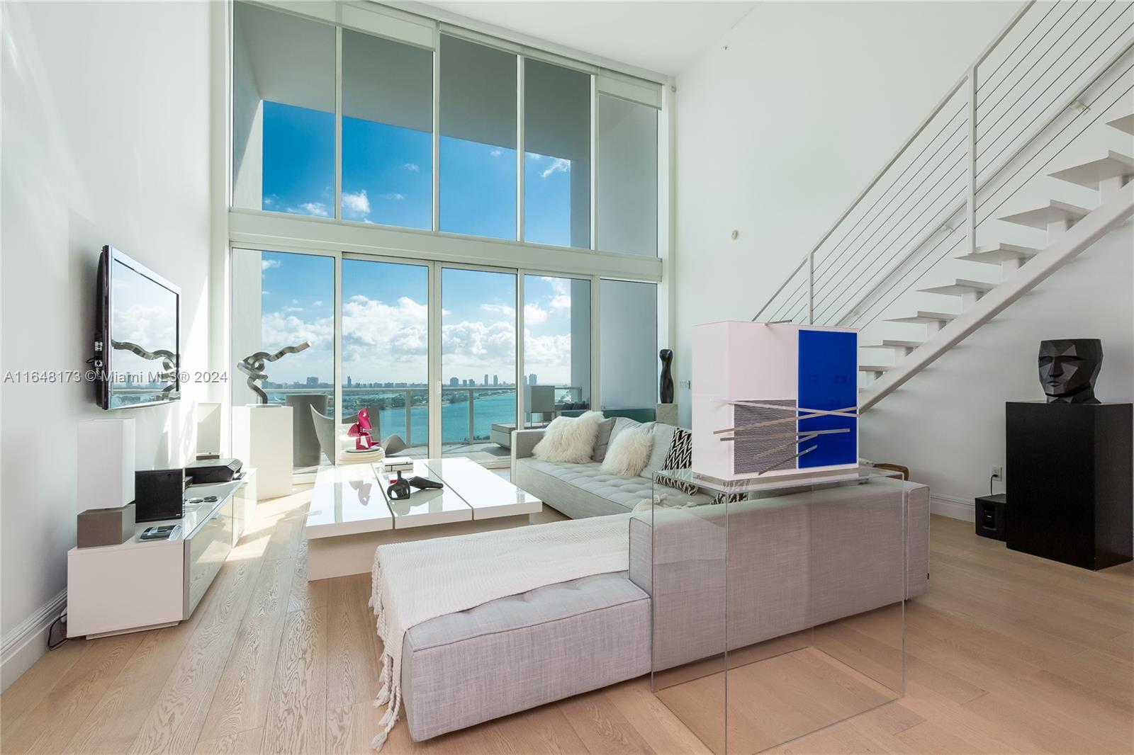 a living room with furniture wooden floor and a large window