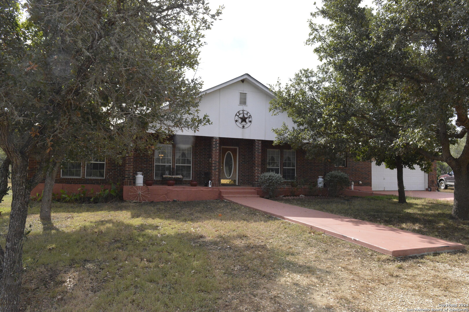 a front view of a house with a yard and trees