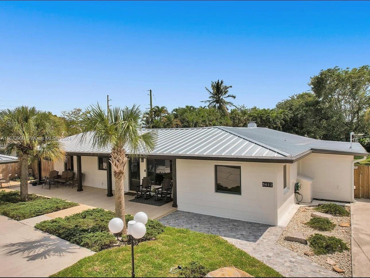 a front view of a house with a yard and outdoor seating