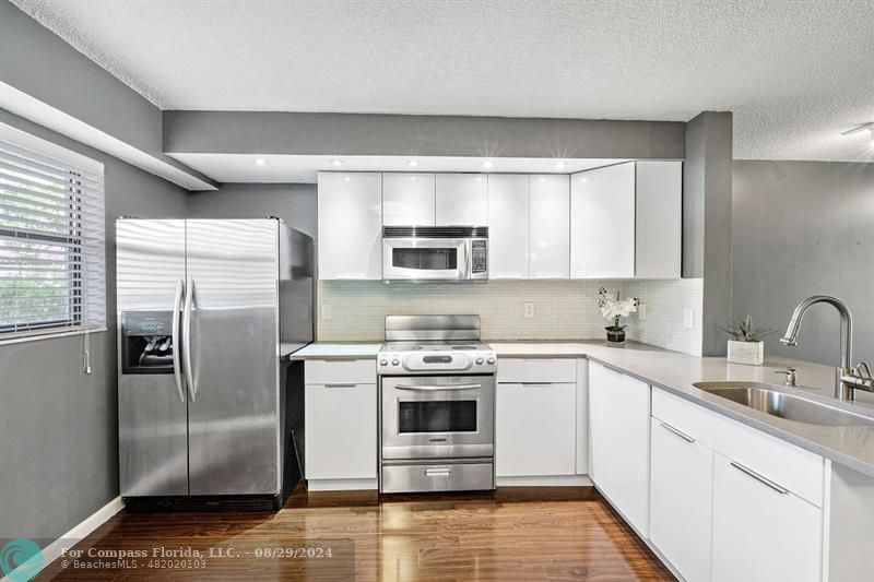 a kitchen with stainless steel appliances granite countertop a stove a refrigerator and a sink