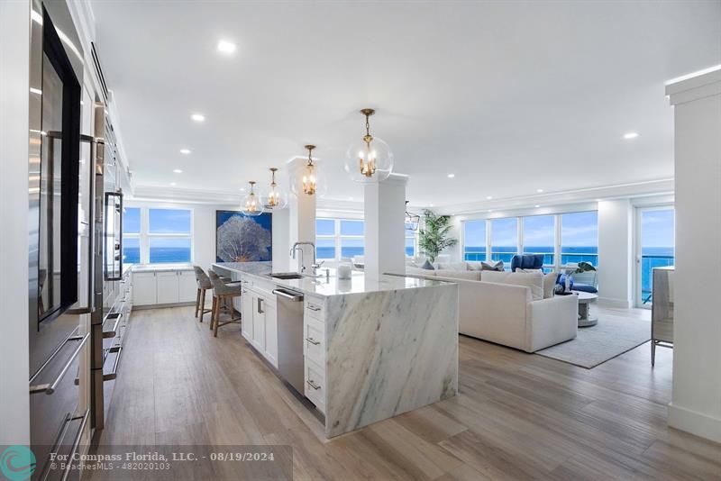 a kitchen with stainless steel appliances kitchen island wooden floors and white cabinets