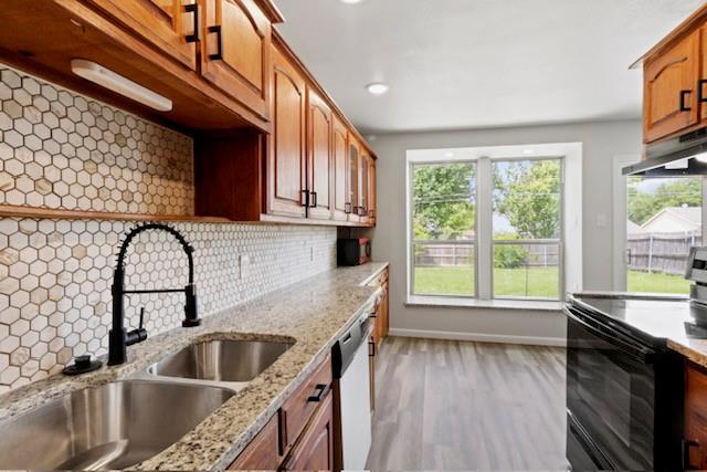 a kitchen with a sink a counter top space and stainless steel appliances wooden floor