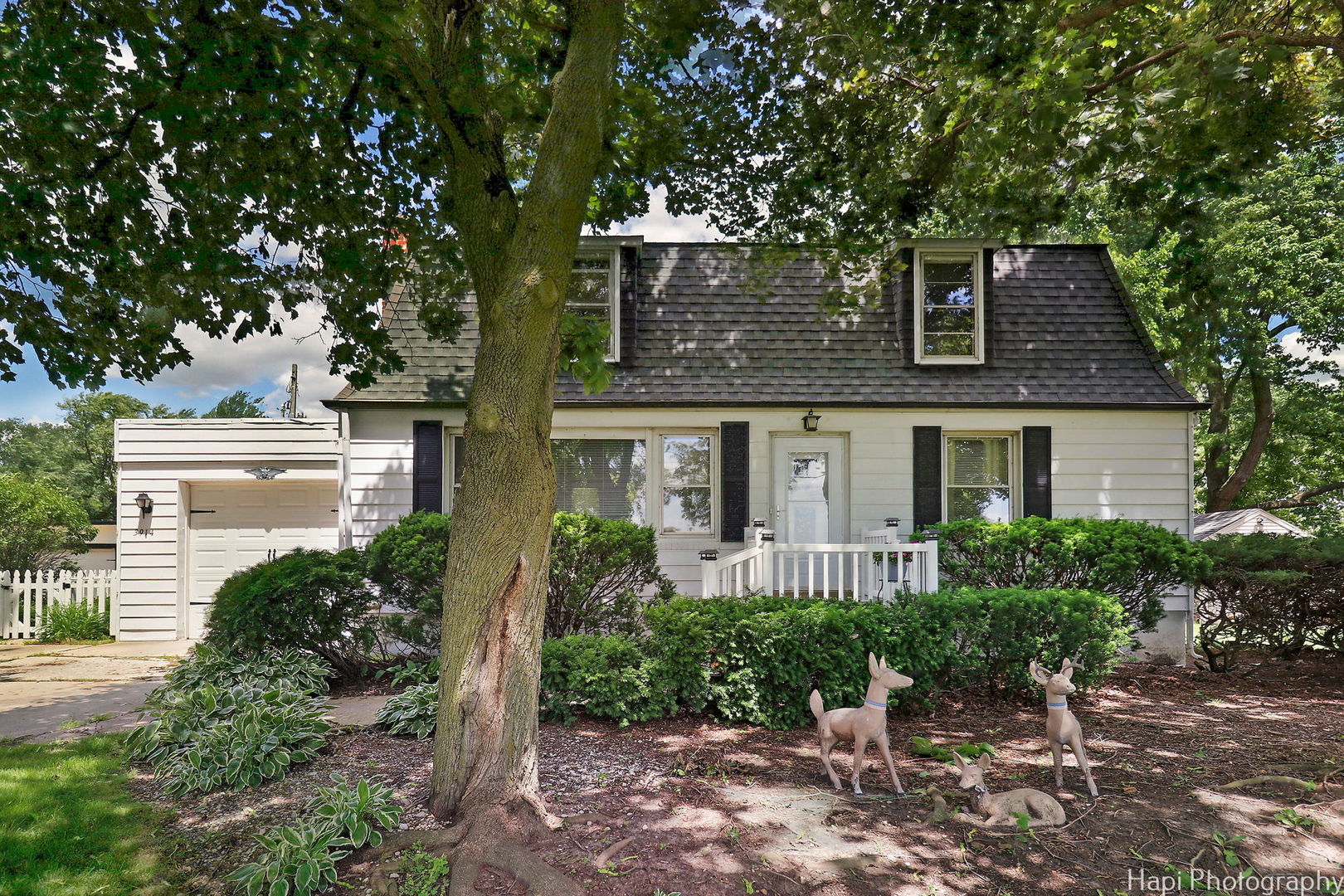 a front view of a house with a yard garage and outdoor seating