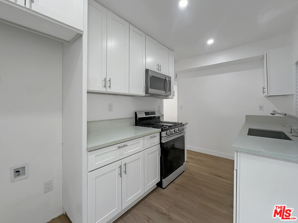 a kitchen with stainless steel appliances granite countertop a stove a sink and a refrigerator