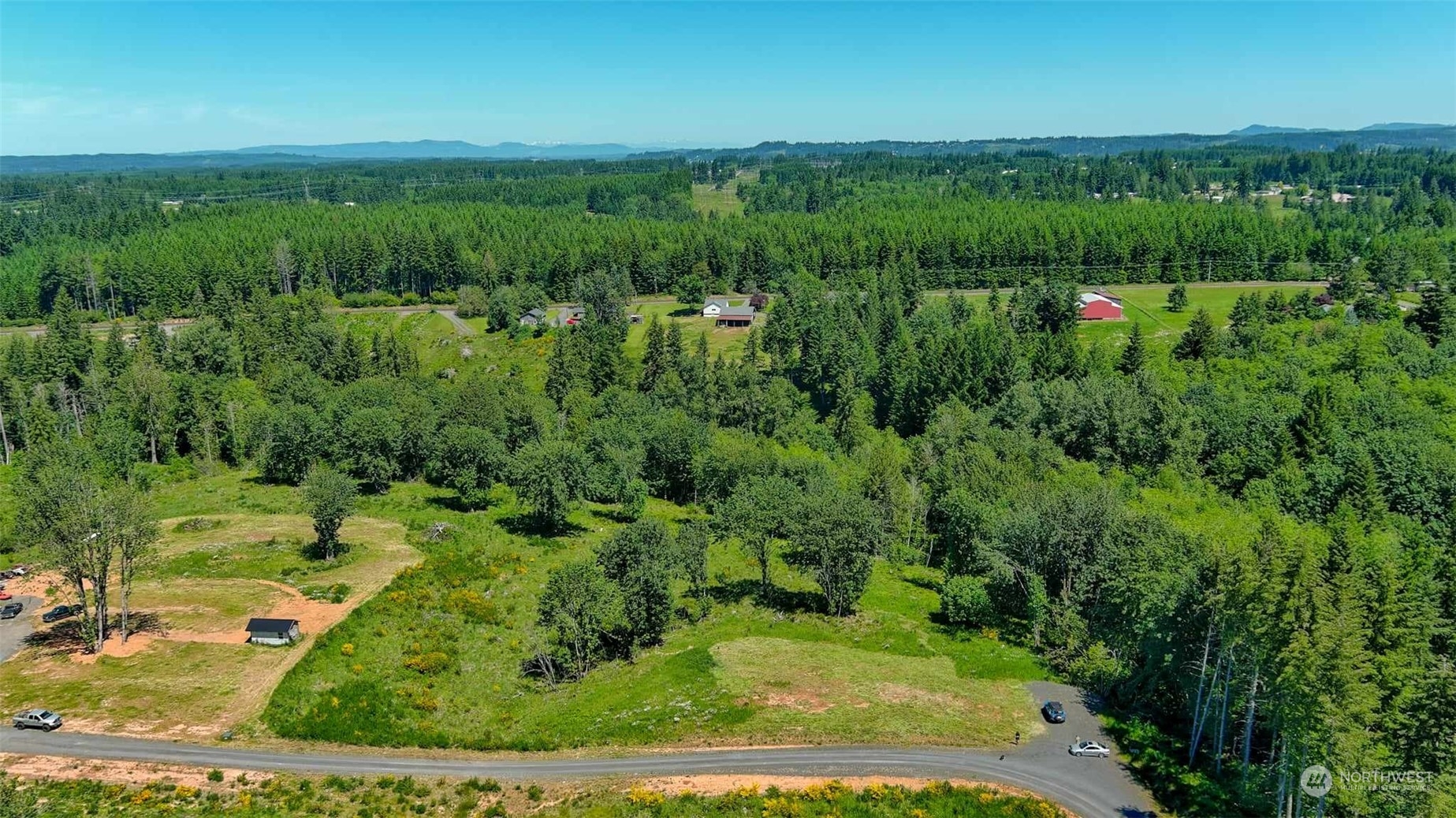 an aerial view of residential houses with outdoor space and trees