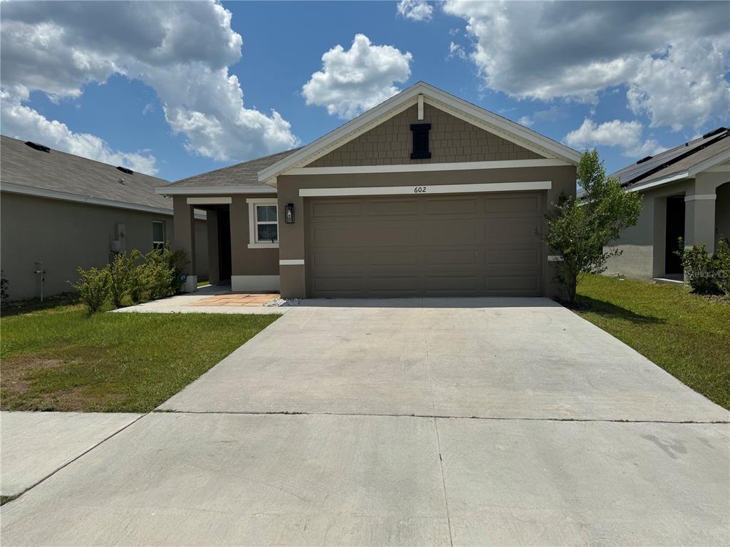 a front view of a house with a yard and garage