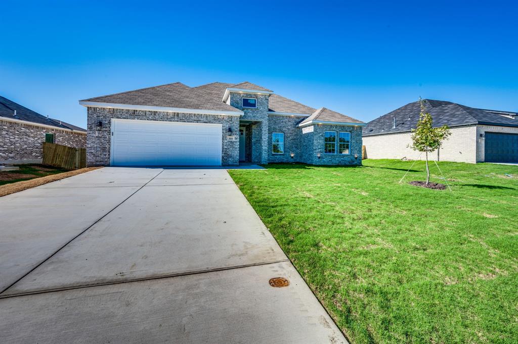 a front view of a house with a yard and garage