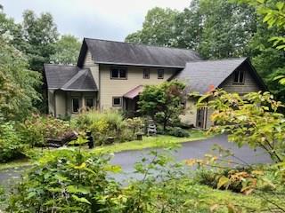 a front view of a house with a yard and a garden