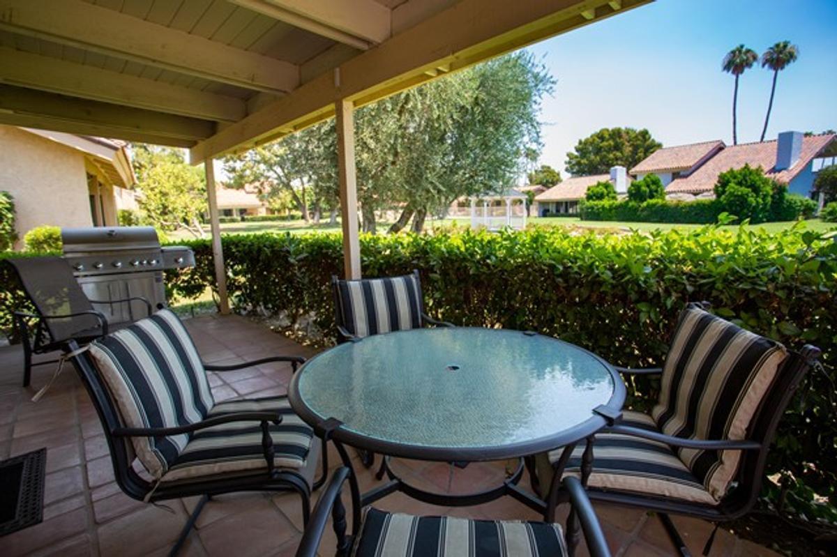 a view of porch with a table chairs and a potted plant