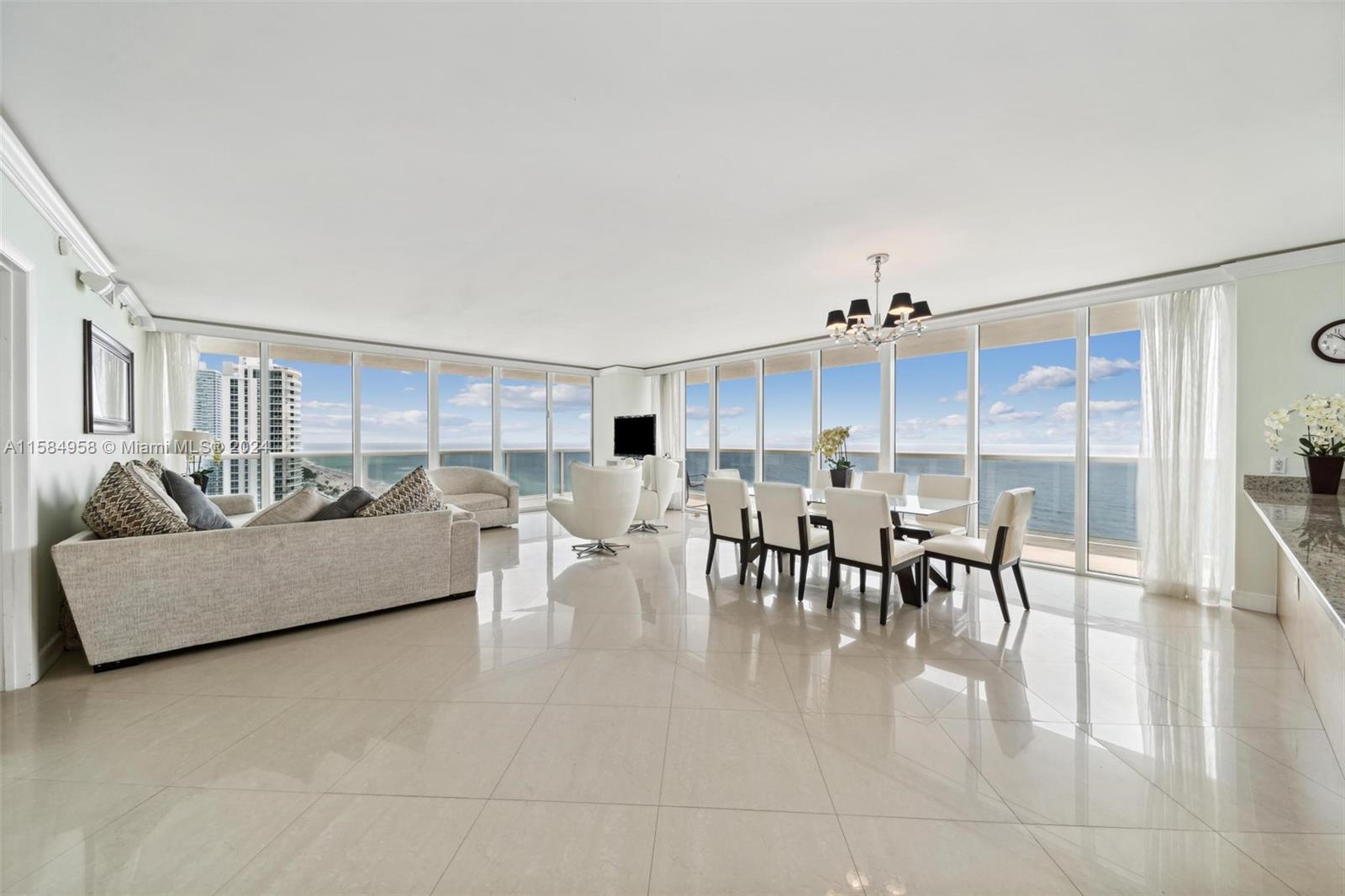 a living room with furniture a dining table and a large window