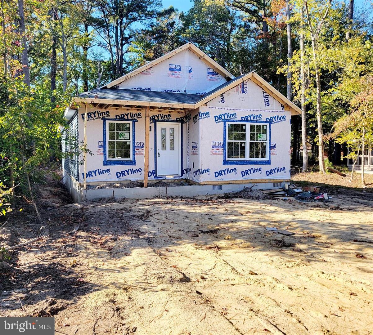 a front view of a house with a yard and trees