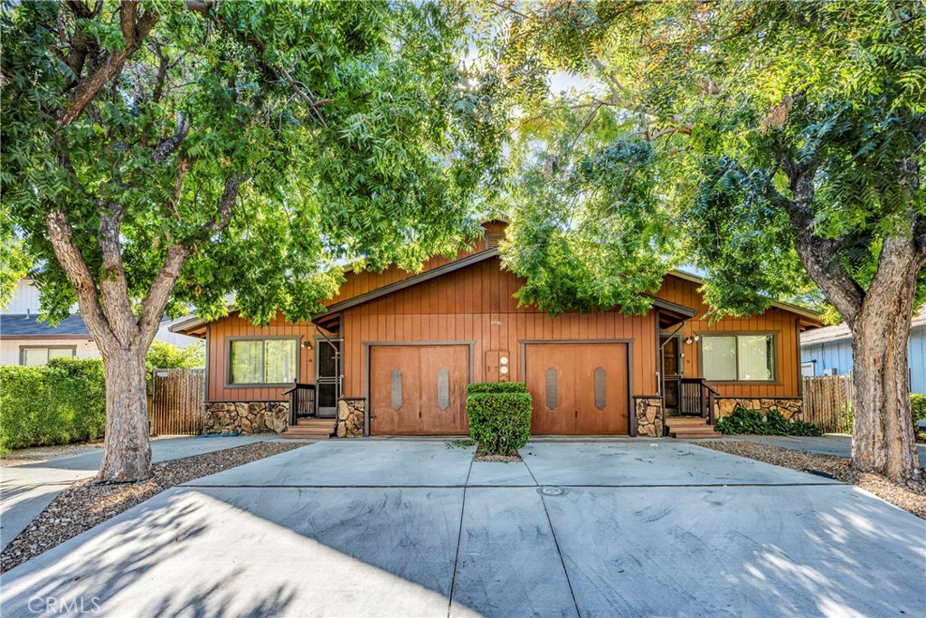 a front view of a house with a yard and potted plants