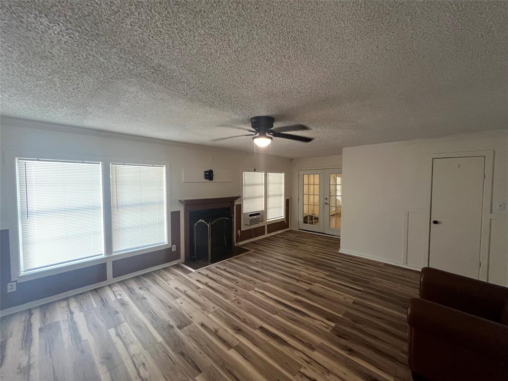 a view of empty room with wooden floor and fireplace