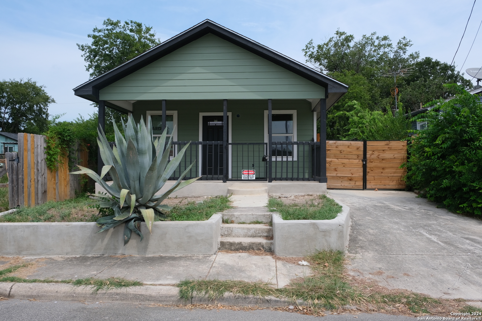 a front view of a house with a garden and plants