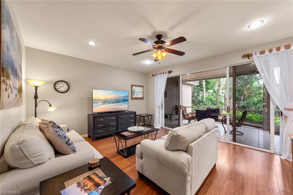 Living room with ceiling fan and hardwood / wood-style flooring