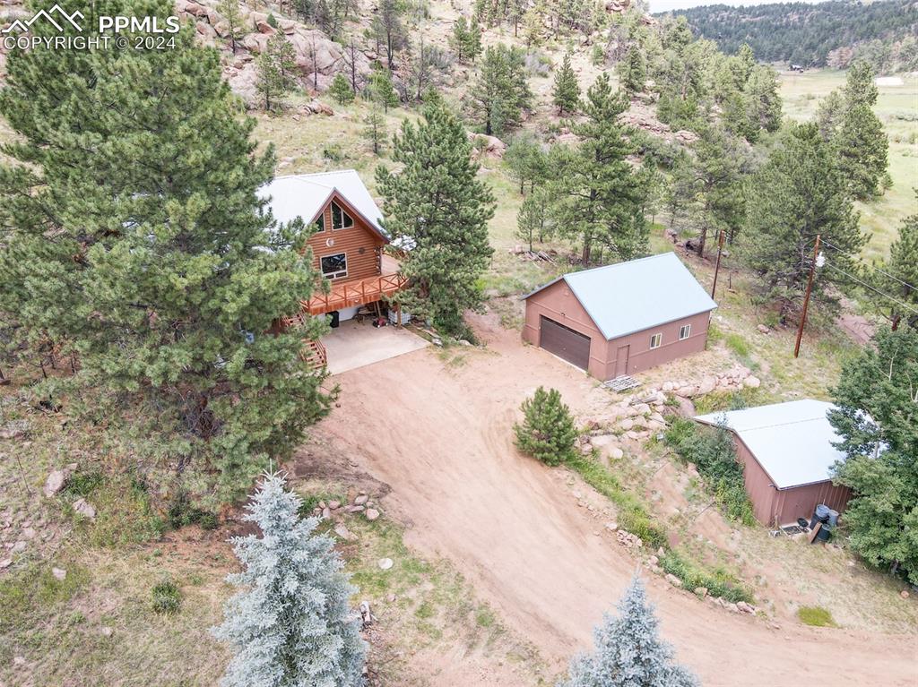 an aerial view of a house with yard and trees all around