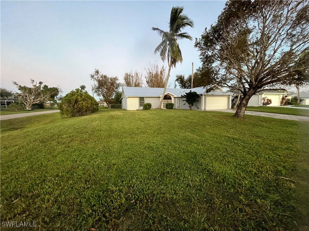 a front view of a house with a yard and palm trees