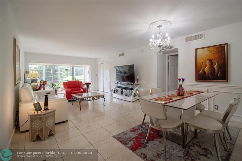 a living room with furniture a dining table and a chandelier